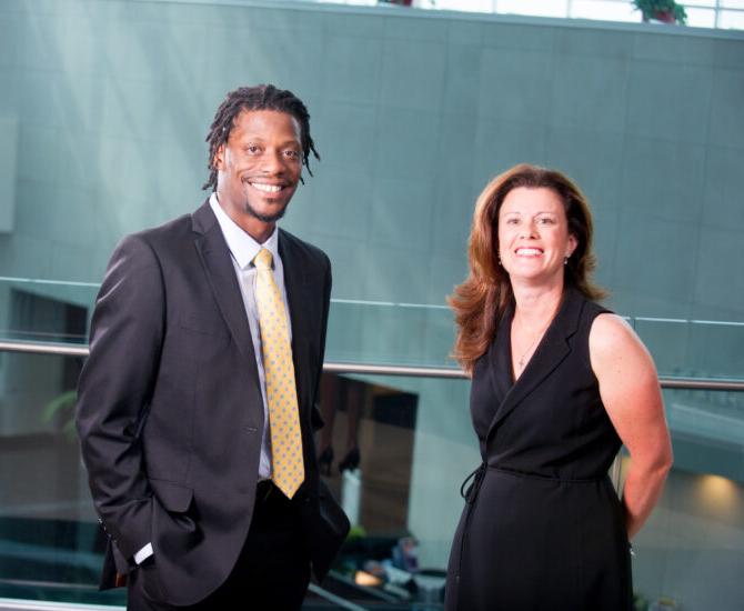 Two students professionally dressed smiling.