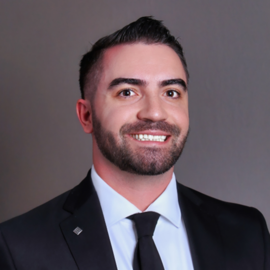 A headshot photo of a person in a suit.